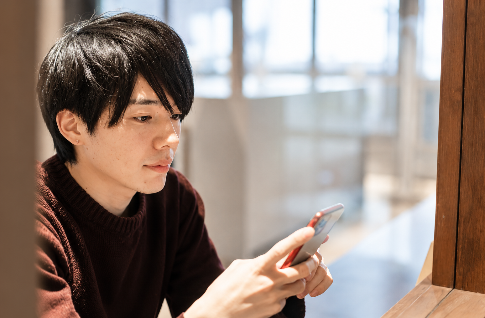 スマホを見ながら婚活に悩む男性